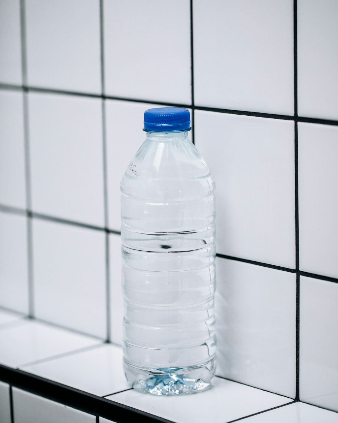 clear-plastic-bottle-on-white-ceramic-tiles-nfdbmg1k4uw